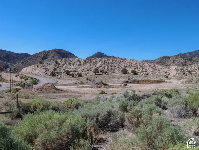 Expansive desert landscape featuring rolling hills and distant mountains