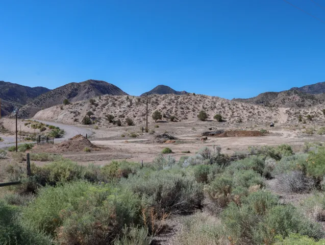 Expansive desert landscape featuring rolling hills and distant mountains