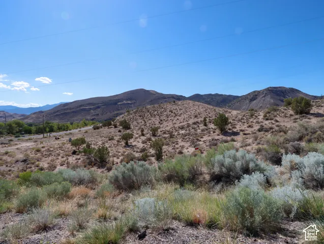 Expansive desert landscape featuring rolling hills and distant mountains