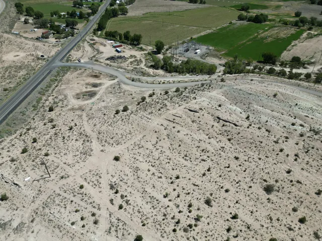 Expansive desert landscape with natural vegetation and visible power lines