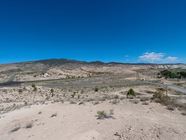 Expansive desert landscape featuring distant mountains and clear blue skies