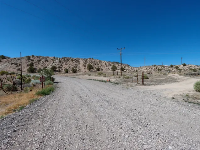 Gravel road winding through undeveloped land featuring desert vegetation and clear blue skies