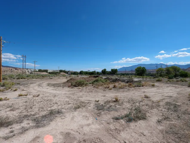 Expansive undeveloped land featuring natural desert vegetation and distant mountain ranges