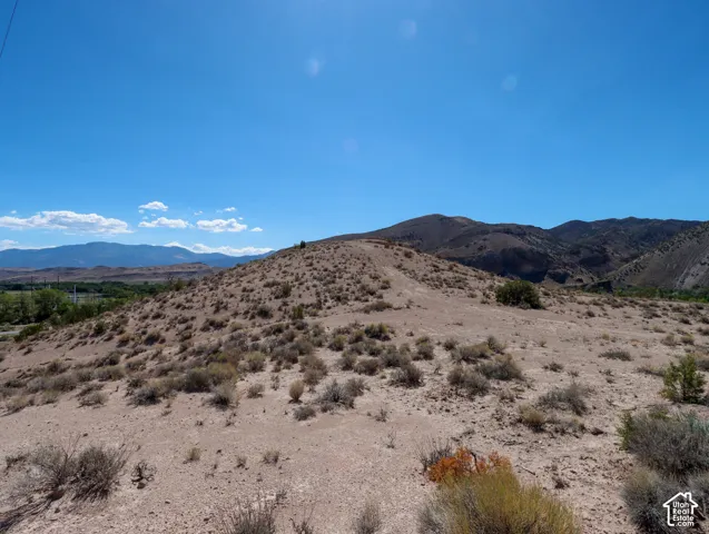 Expansive desert landscape featuring rolling hills and sparse vegetation