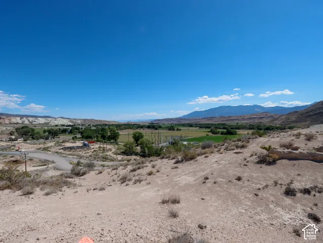 Expansive desert landscape featuring distant mountains and a vibrant green valley