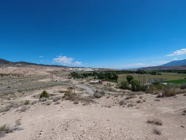 Expansive desert landscape featuring rugged terrain and distant green valleys
