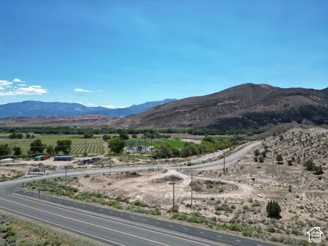 Expansive acreage featuring a paved road frontage, natural desert landscaping, and distant mountain ranges