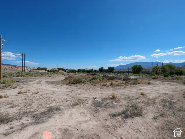 Expansive undeveloped land featuring natural desert vegetation and distant mountain ranges