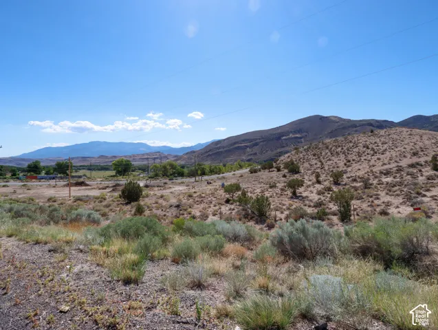 Expansive desert landscape featuring rolling hills and distant mountains
