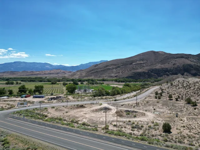 Expansive acreage featuring a paved road frontage, natural desert landscaping, and distant mountain ranges