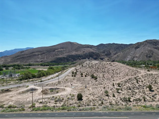 Expansive desert landscape featuring rugged mountains and a clear blue sky