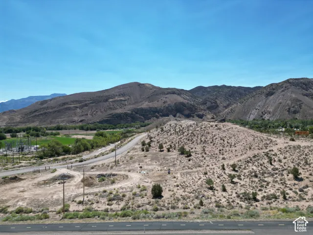 Expansive desert landscape featuring rugged mountains and a clear blue sky