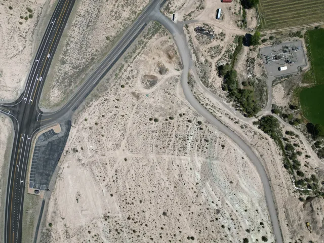 Expansive land parcel featuring direct highway frontage and a paved parking area