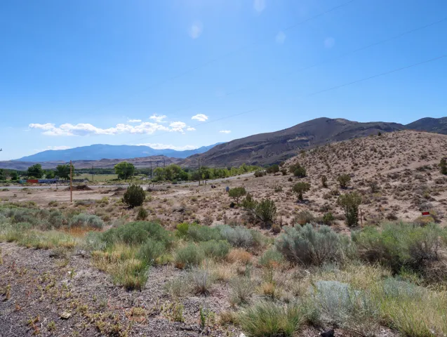 Expansive desert landscape featuring rolling hills and distant mountains
