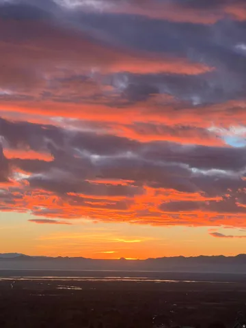 Expansive vistas featuring dramatic sunset skies and distant mountain silhouettes visible from the property's elevated location
