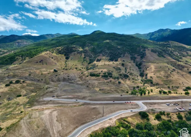 Expansive mountain landscape with diverse terrain, including lush green peaks and arid slopes