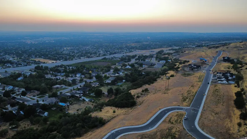 Expansive aerial perspective showcasing a developing residential area with paved streets and new construction homes