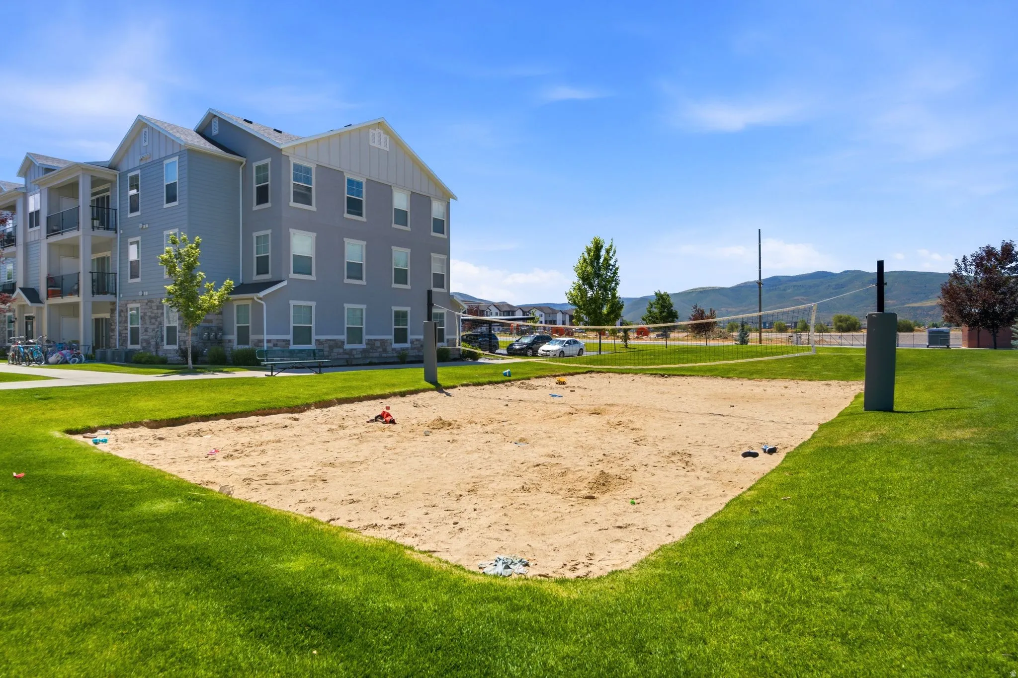 Sand volleyball court surrounded by a manicured lawn