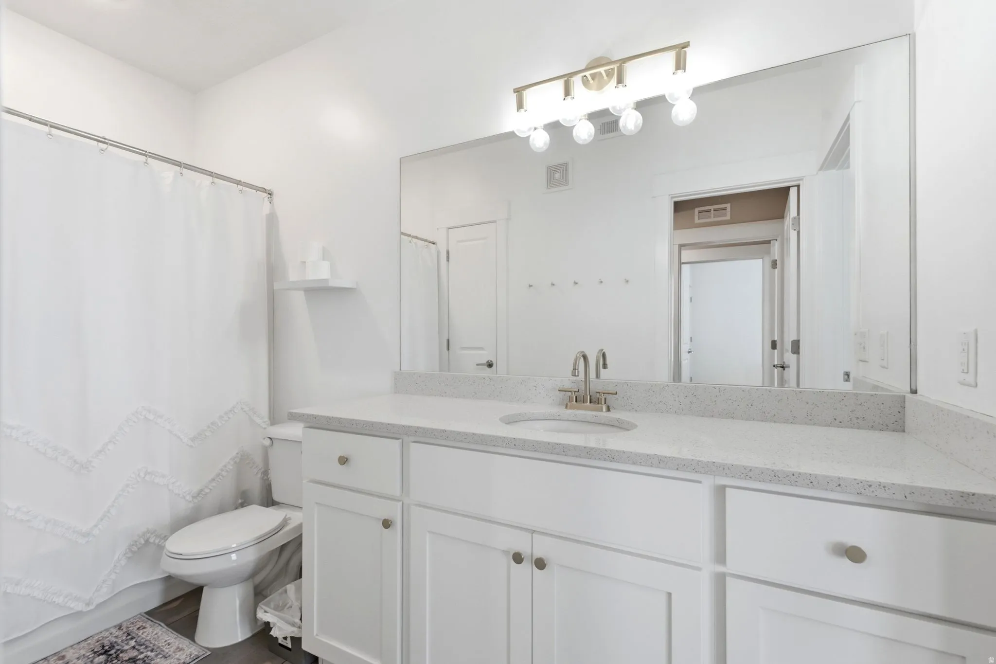 Bathroom featuring a spacious vanity with a light-toned countertop, integrated sink, and brushed nickel faucet