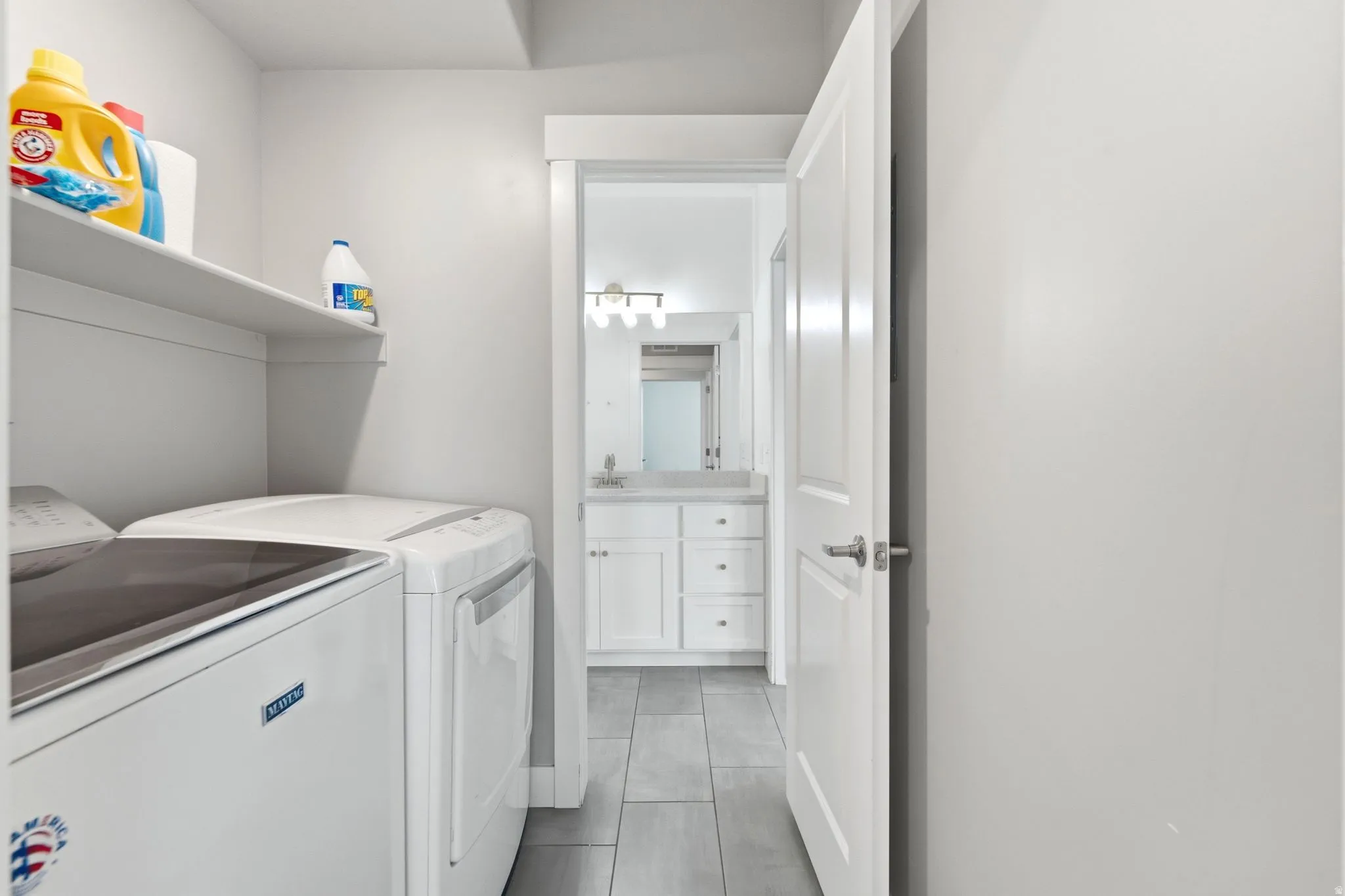 Laundry area with built-in shelving and tile flooring