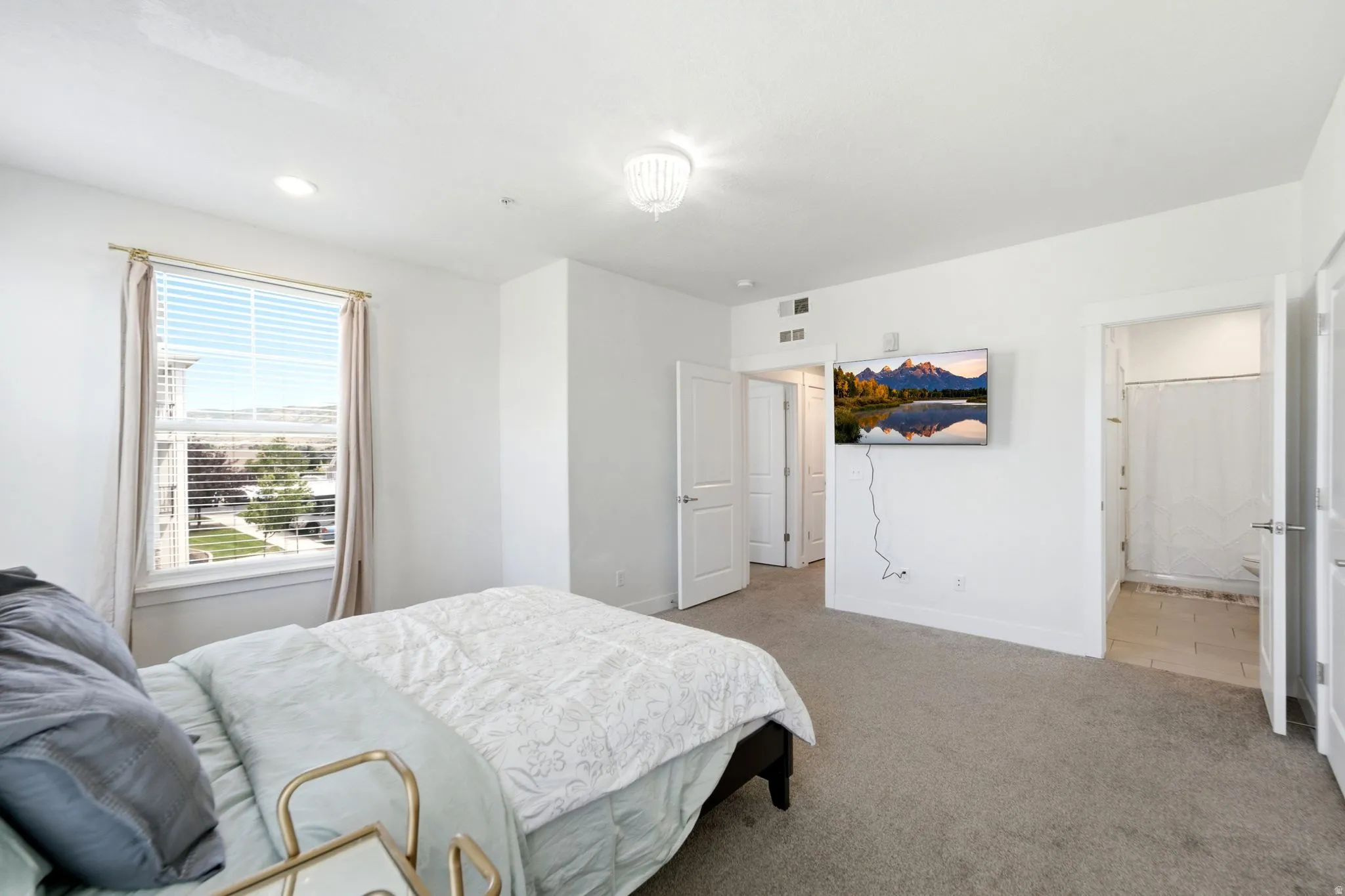 Spacious room featuring neutral carpeting, recessed lighting, and a ceiling-mounted light fixture