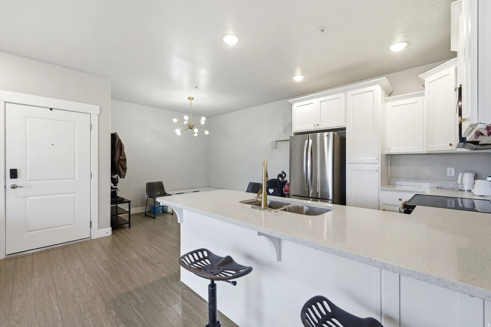 Open-concept kitchen and living area featuring a large island with a double basin sink and integrated breakfast bar