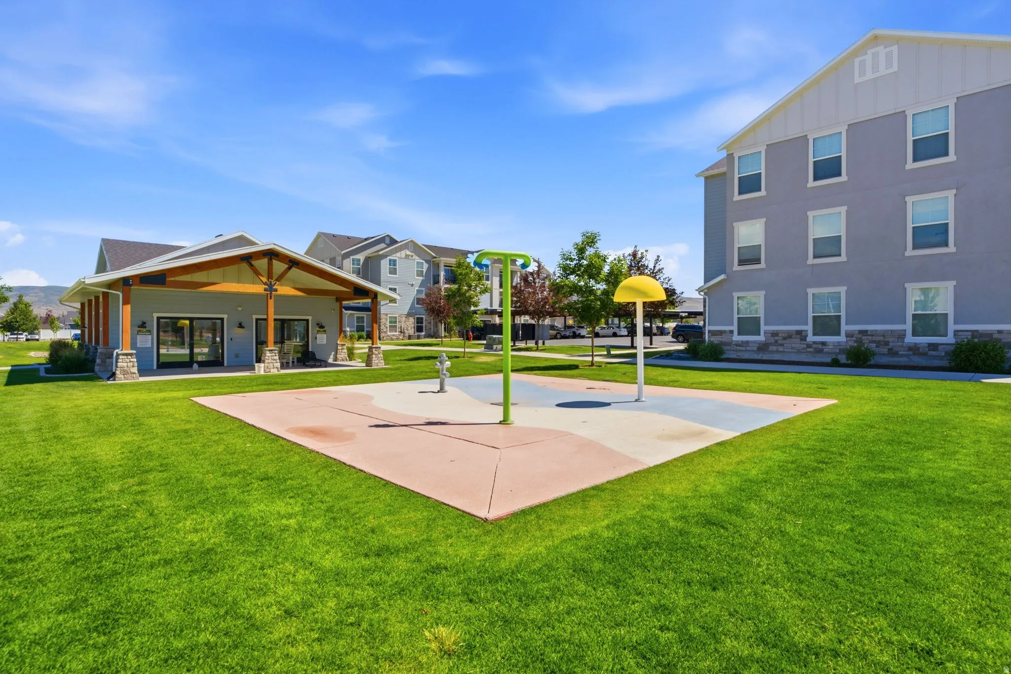 Expansive green space featuring a splash pad with multiple water features