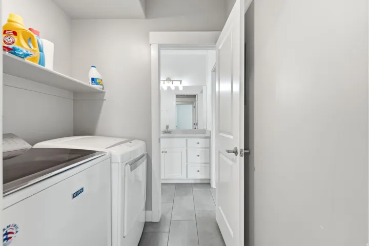 Laundry area with built-in shelving and tile flooring