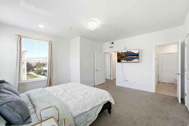 Spacious room featuring neutral carpeting, recessed lighting, and a ceiling-mounted light fixture