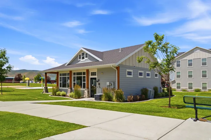 Contemporary clubhouse with an expansive covered porch, stone accents, and large windows