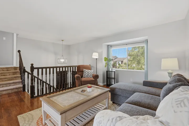 Open-concept living area featuring rich wood-finish flooring and light gray wall tones