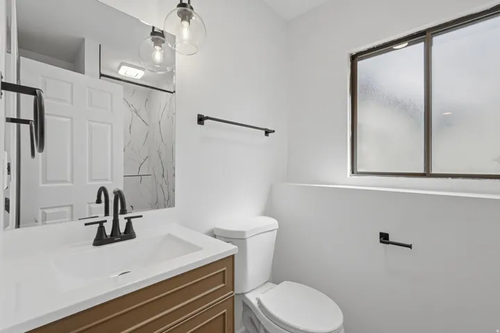 Bathroom featuring a brown wood-finish vanity with a white countertop and integrated sink