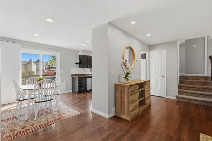 Open-concept living area featuring wood-finish flooring, recessed lighting, and a sliding glass door leading to outdoor space