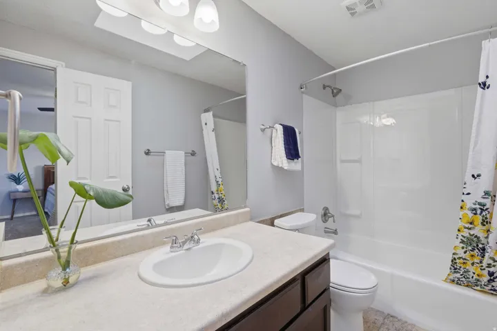Bathroom featuring a white integrated sink, light-colored countertop, and dark wood-finish cabinetry
