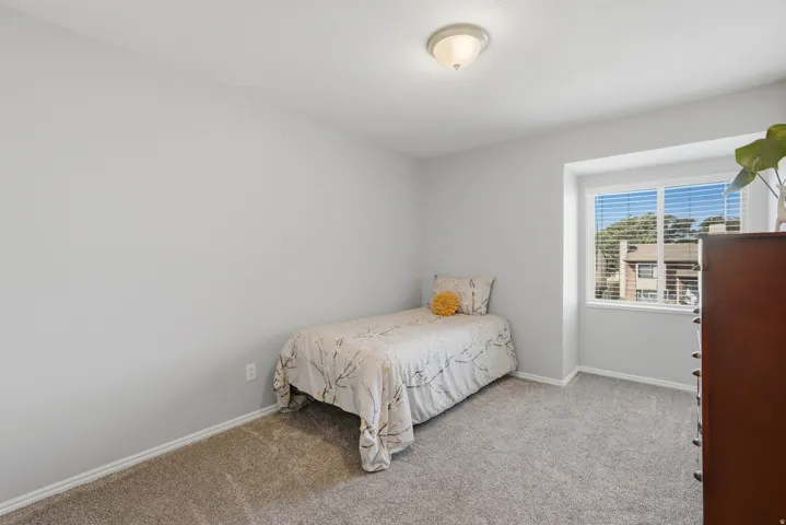 Carpeted room with a double-paned window, white trim, and a flush-mount ceiling light