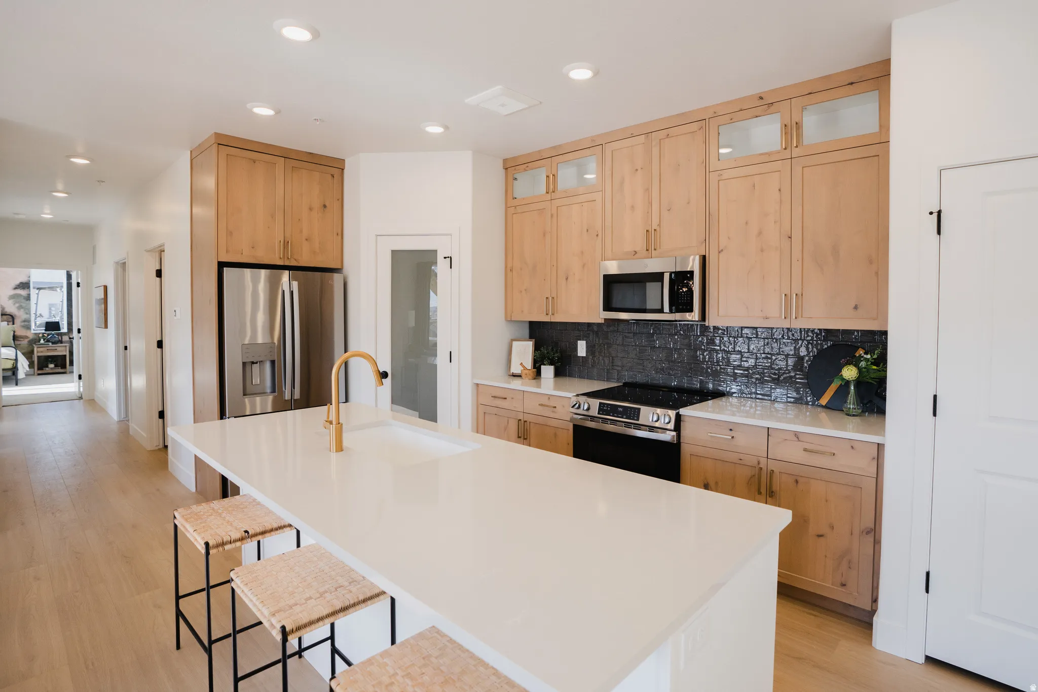 Modern kitchen with a large central island featuring a built-in sink and gold-finish faucet