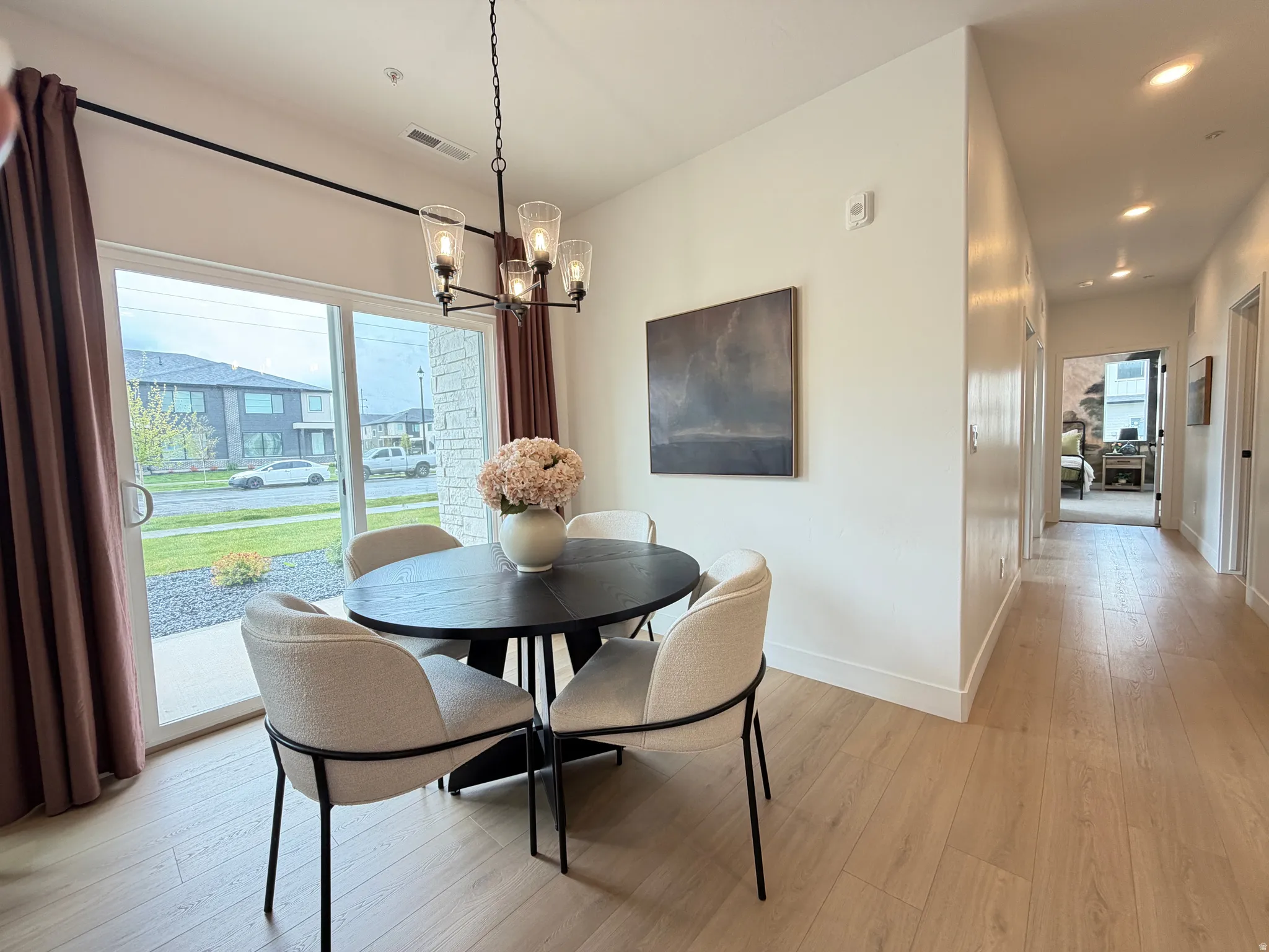 Dining area featuring wood-finish flooring and a contemporary chandelier