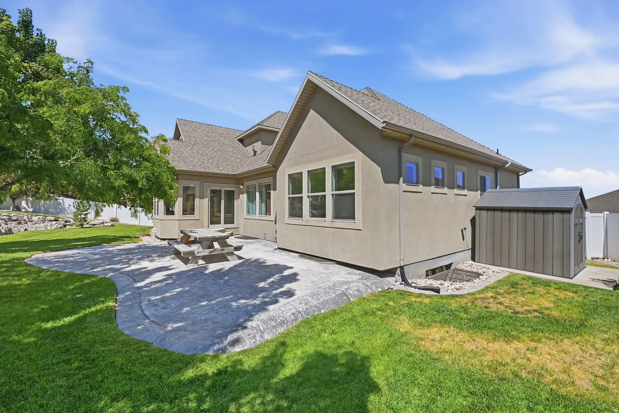 Rear exterior featuring a stucco finish, multi-pane windows, and a shingled roof