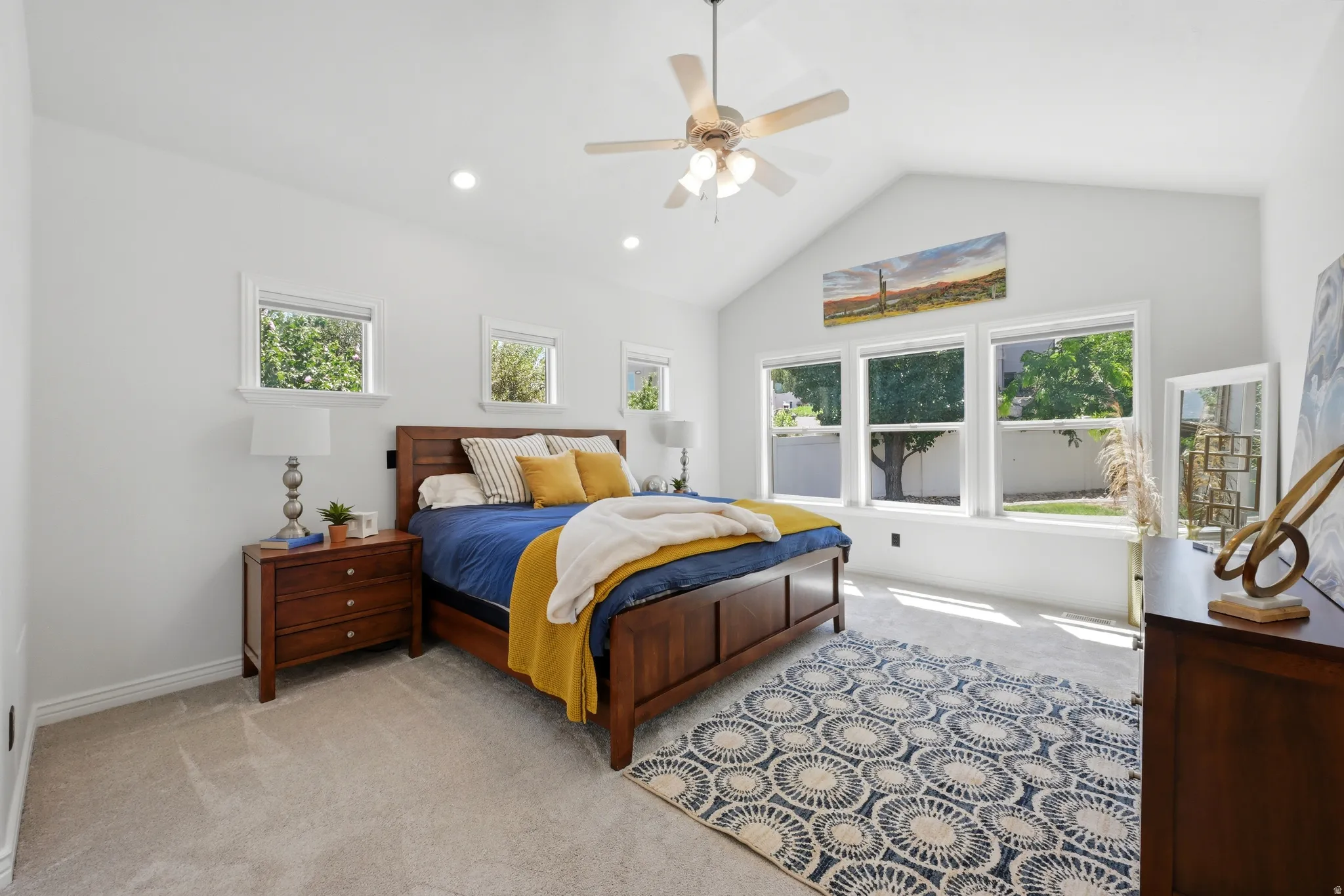 Spacious room featuring a vaulted ceiling with a ceiling fan, recessed lighting, and light-toned carpet flooring