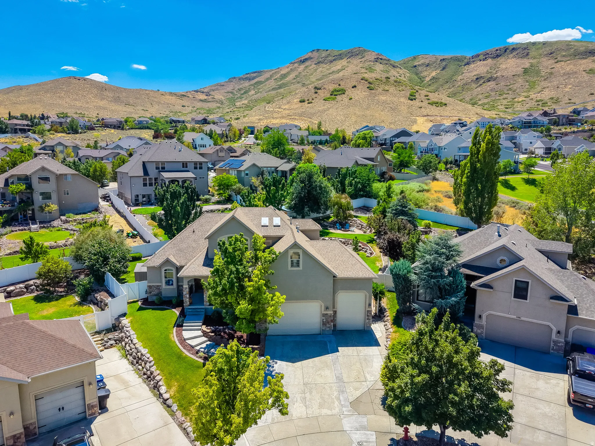 Residence featuring a stone and stucco exterior, a multi-car garage, and a concrete driveway