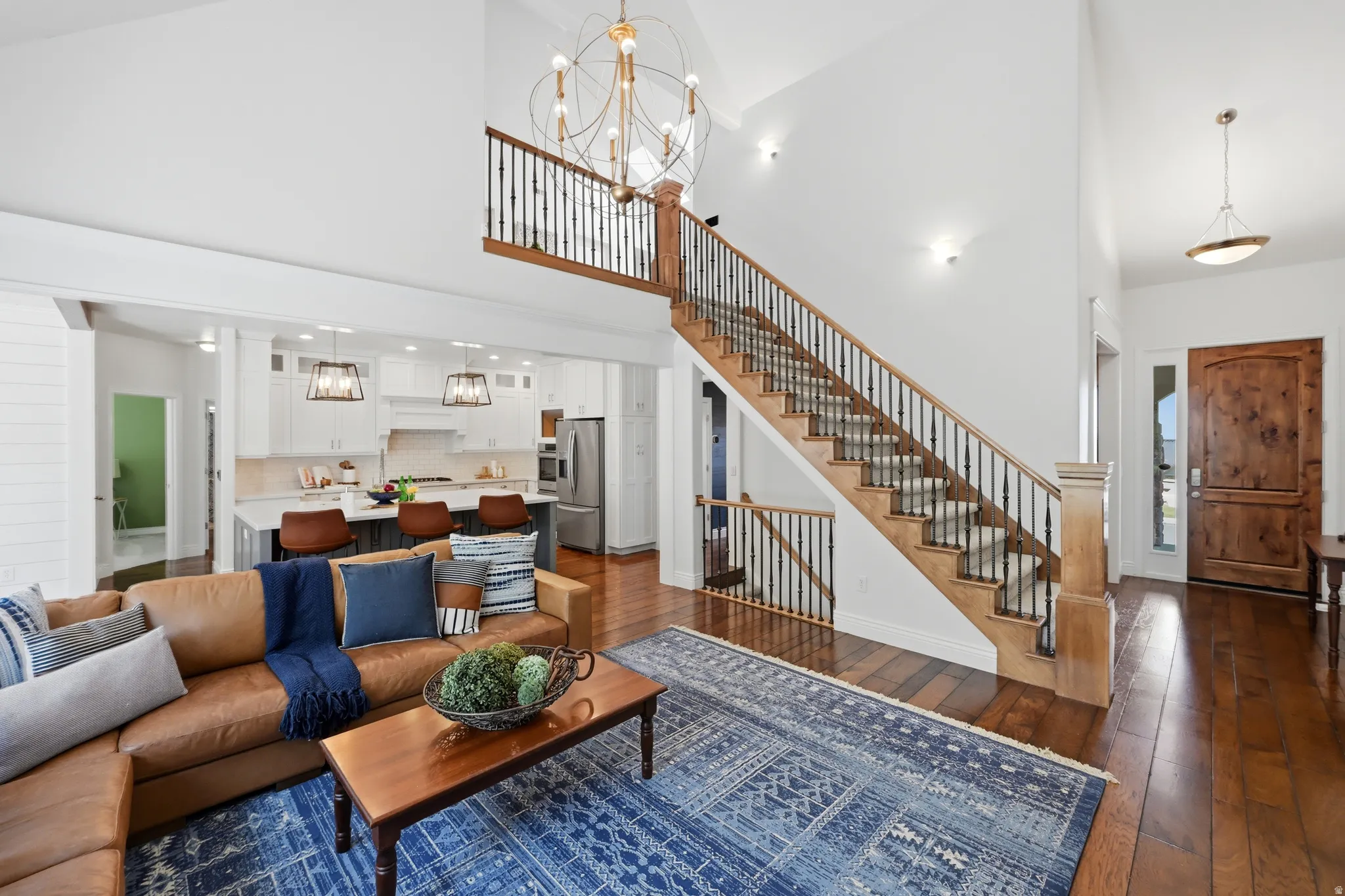 Two-story foyer featuring a grand wooden staircase with wrought iron balusters and wood-finish flooring