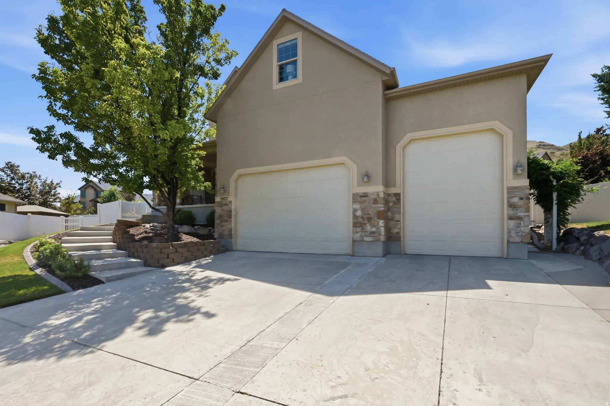 Stucco exterior with stone accents and two garage doors