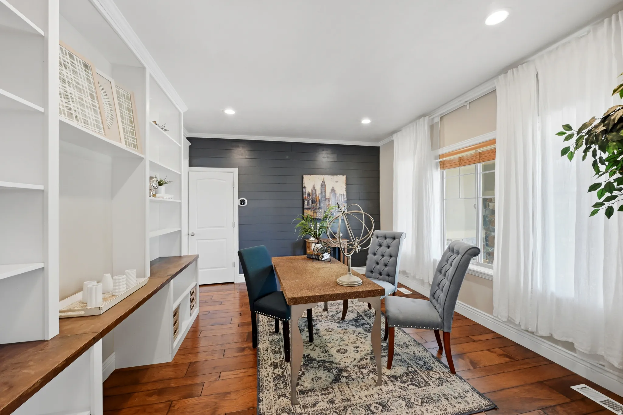 Built-in white shelving with a wood-finish countertop, recessed lighting, and wood-finish flooring