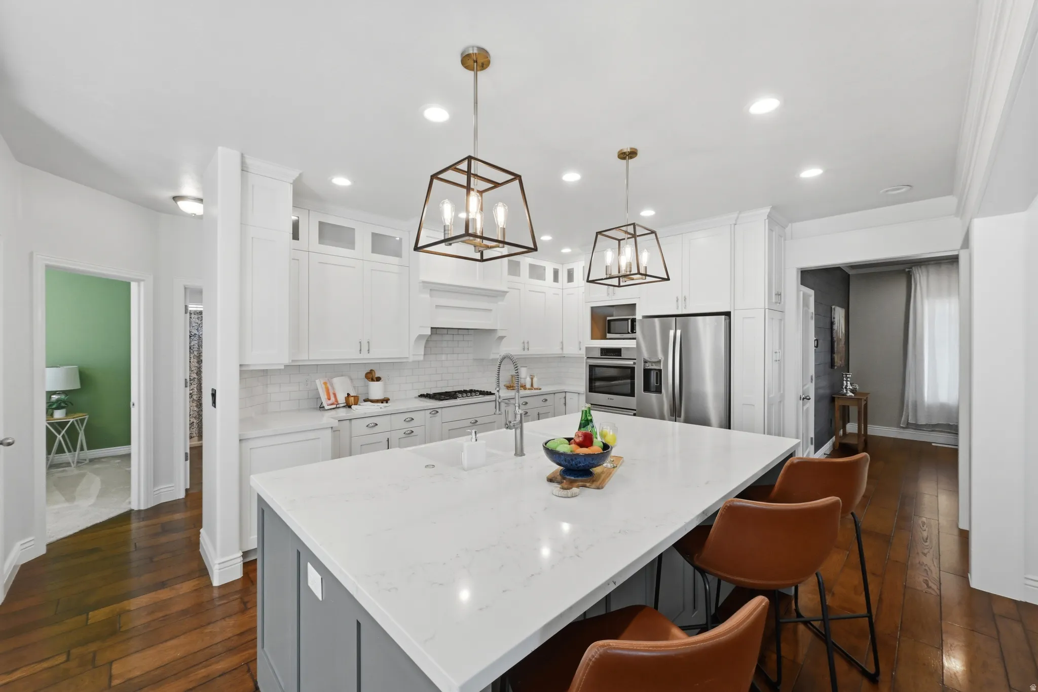 Modern kitchen featuring a large central island with a light-colored countertop and a gray base