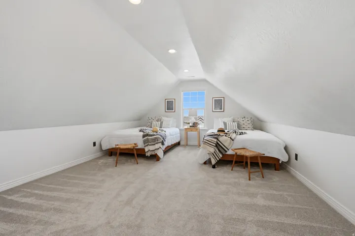 Carpeted room featuring a centered window, vaulted ceilings, and recessed lighting