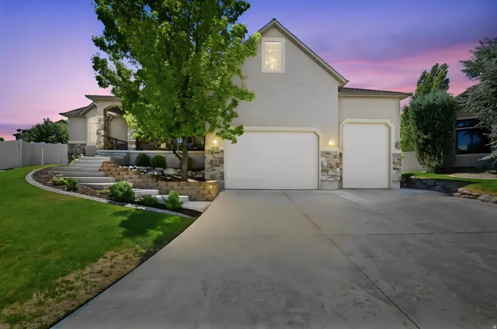 Stucco and stone exterior featuring a two-car garage