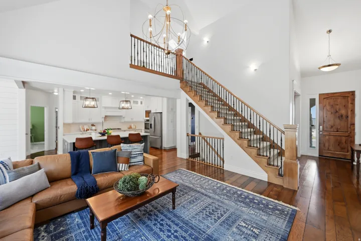 Two-story foyer featuring a grand wooden staircase with wrought iron balusters and wood-finish flooring