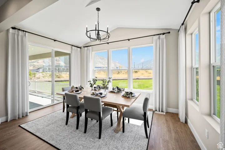 Vaulted ceiling dining area with wood-finish flooring