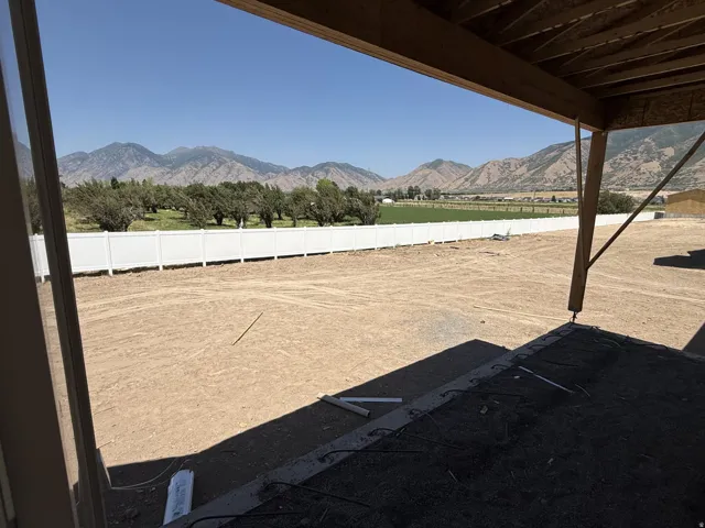 Expansive backyard space with a white privacy fence