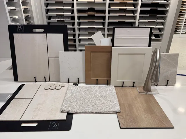 Selection of interior finishes featuring various flooring options, cabinet door styles, countertop samples, and a brushed metal faucet
